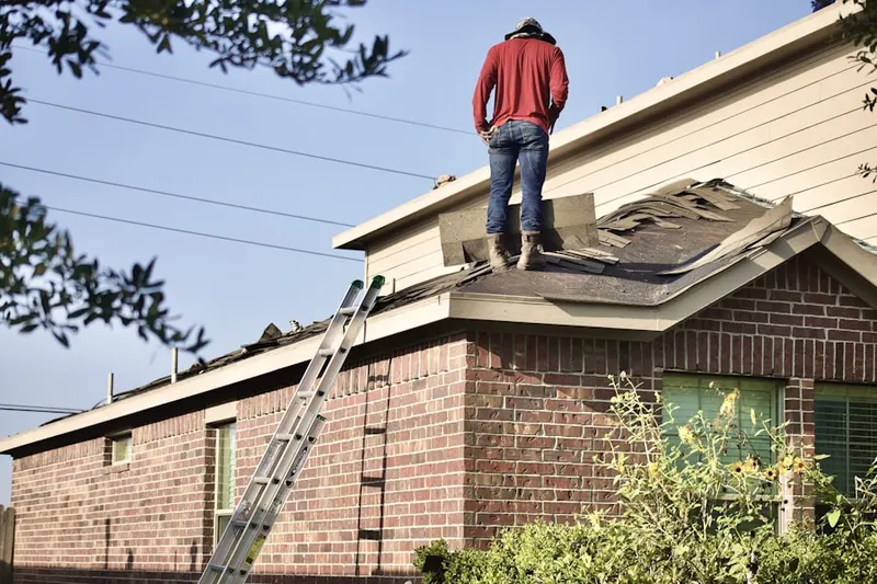 Professional roofer working on a residential roof in The Claremont Club